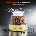 Pepper grinder with adjustable coarseness feature, filled with multicolored peppercorns.